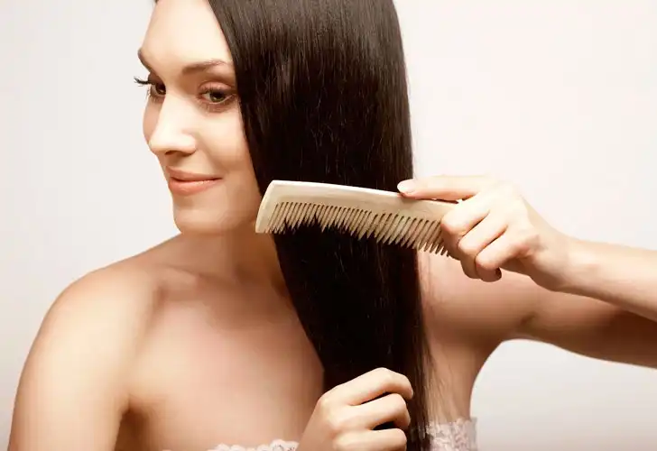 жінка розчісує волосся